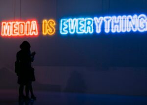 a person standing in front of a neon sign